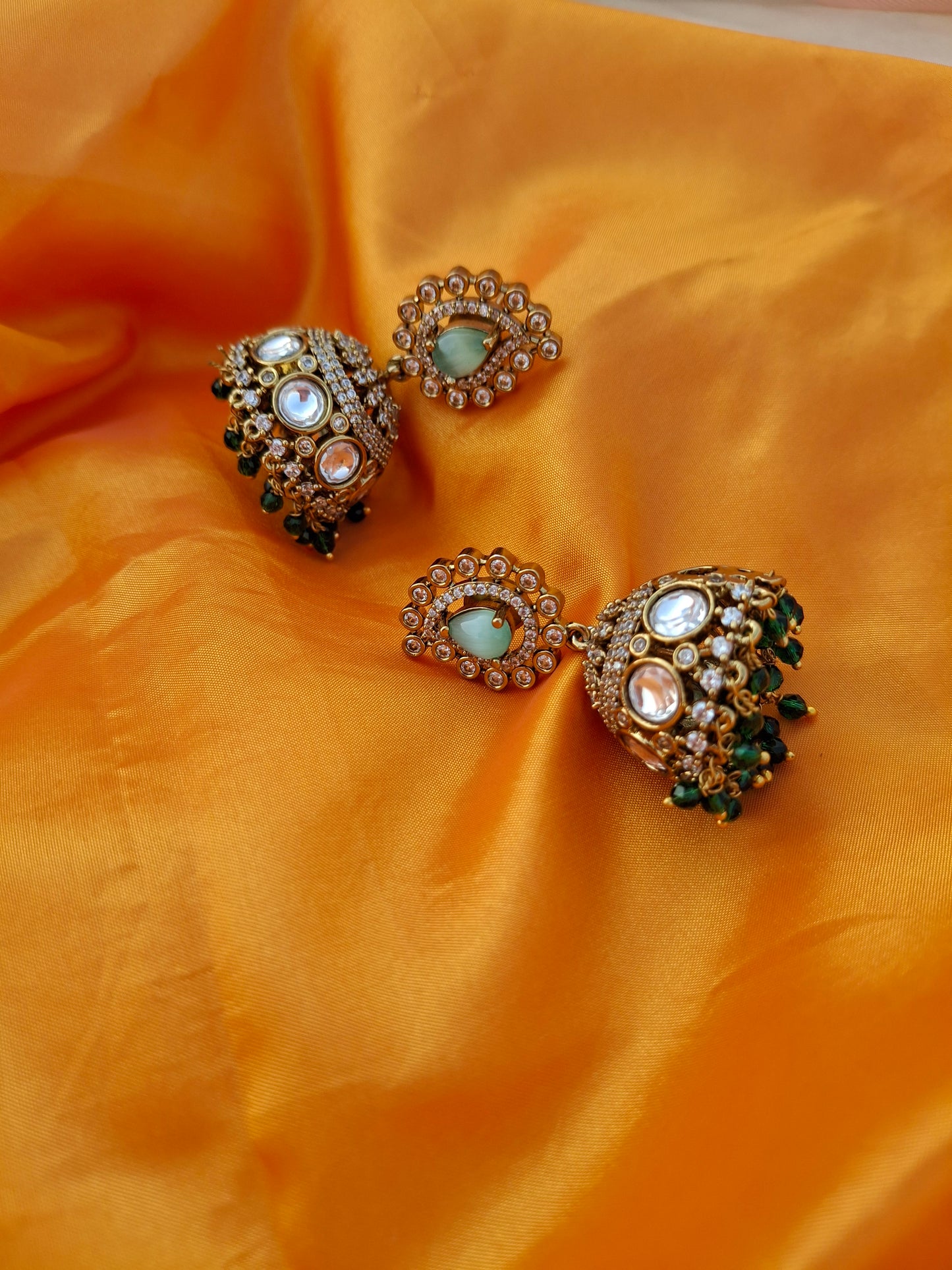 Gold-Plated Jhumka Earrings with Pastel Green, White, and Dark Green Stones